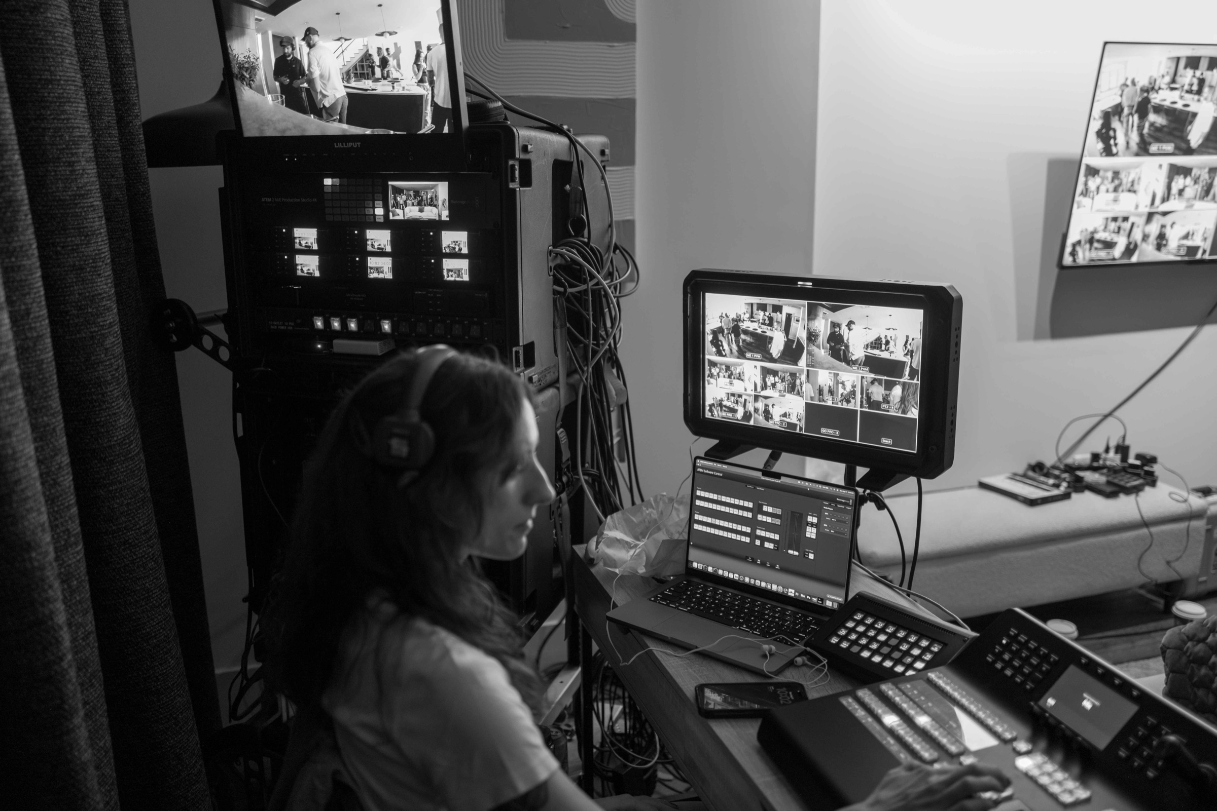 Switcher operator in headphones running a multi-camera feed at video village